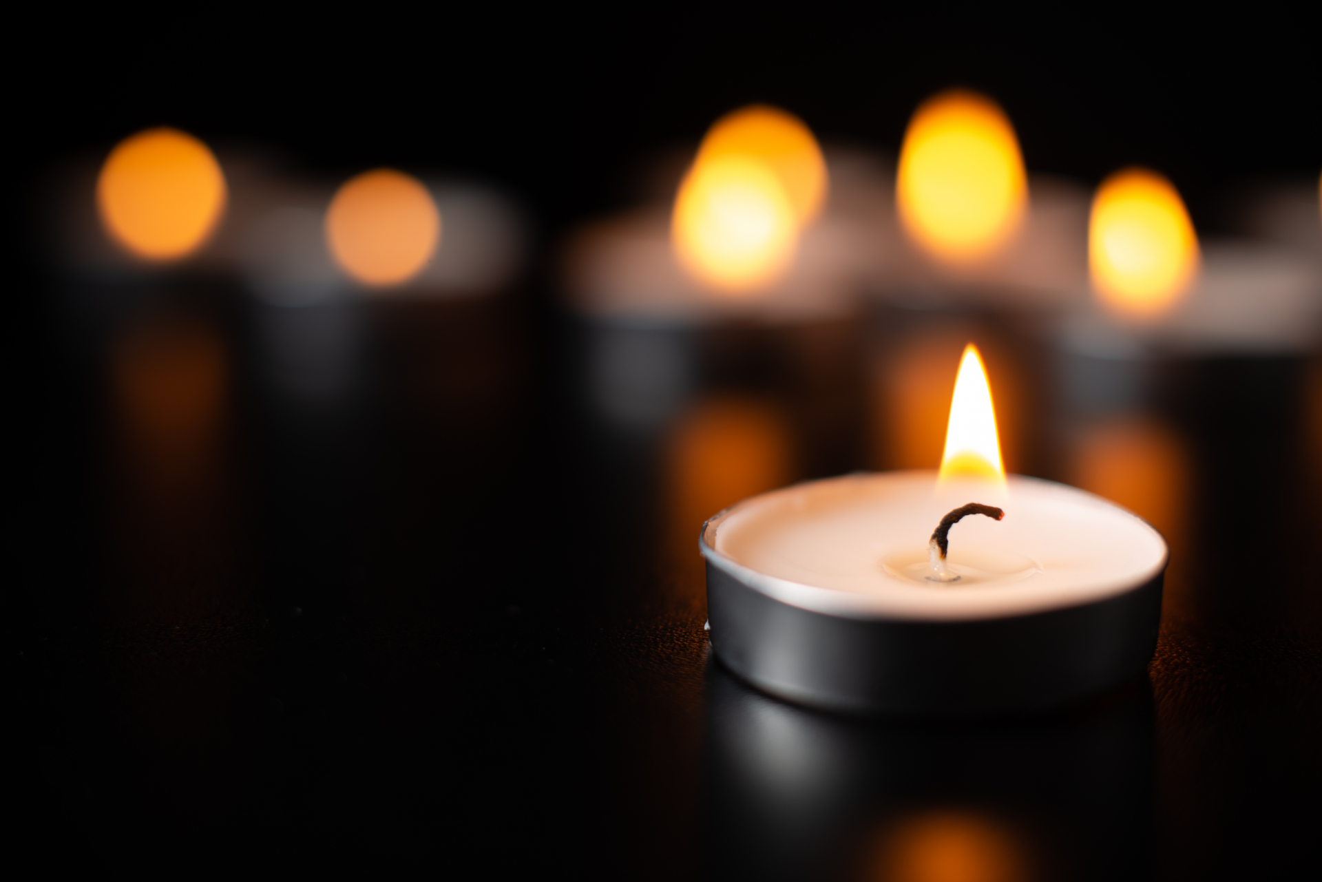 front-view-burning-candles-pitch-black-surface.jpg